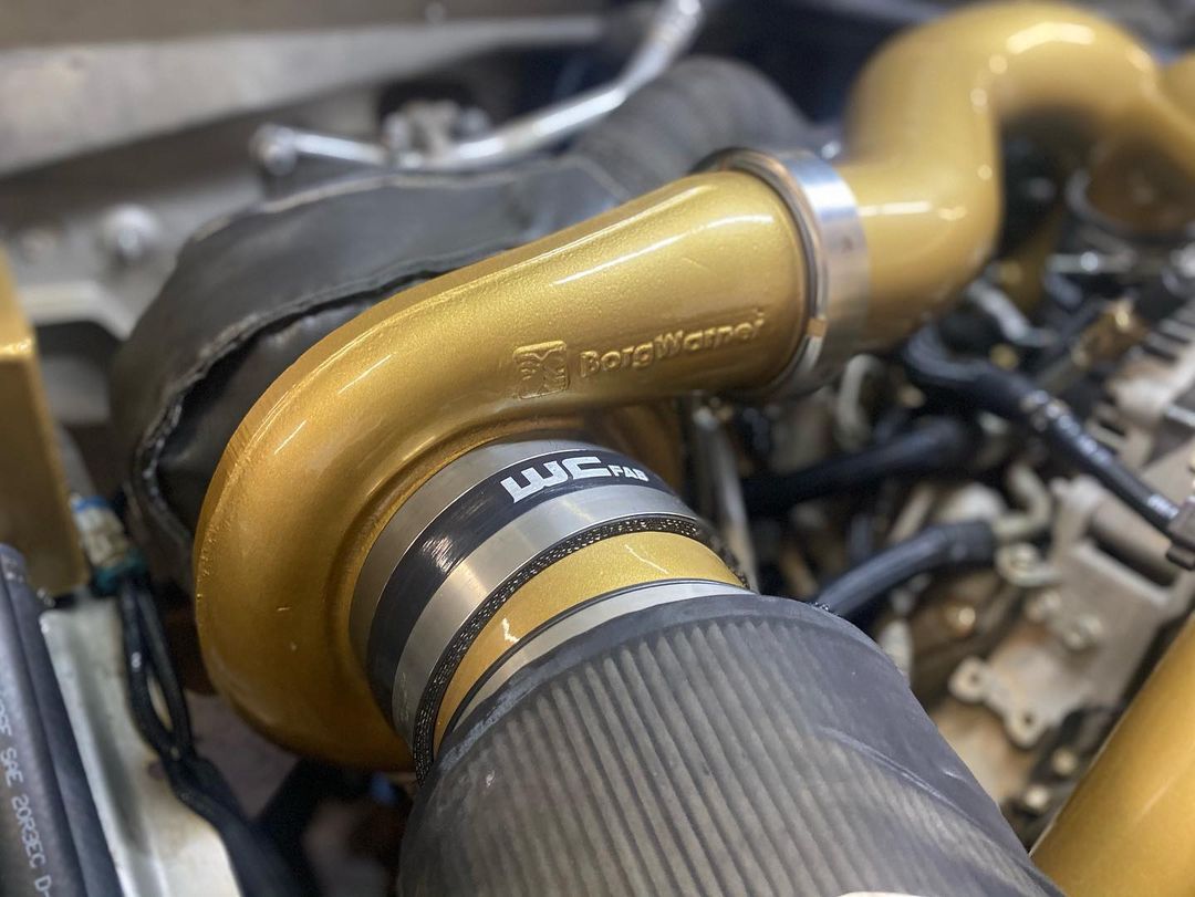A close up of a turbocharger on a car engine.