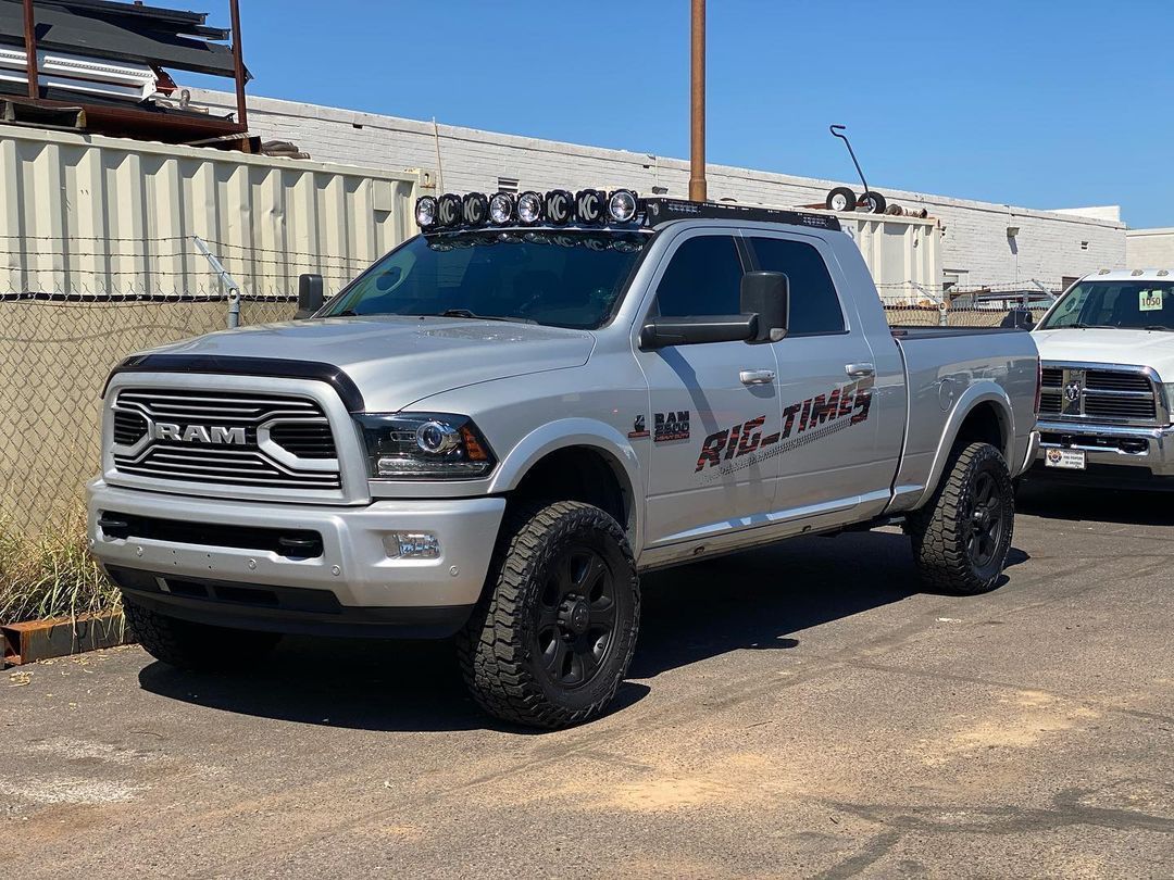 A silver ram truck is parked in a parking lot.