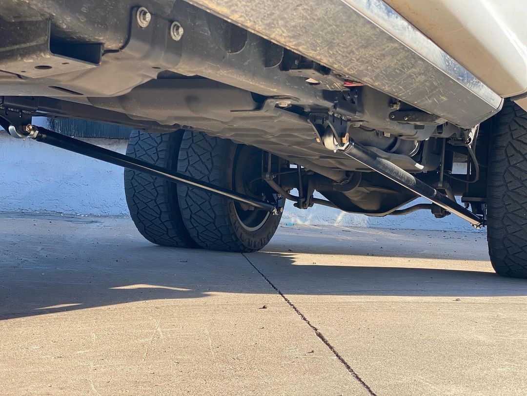 A close up of the underside of a truck parked on a sidewalk.