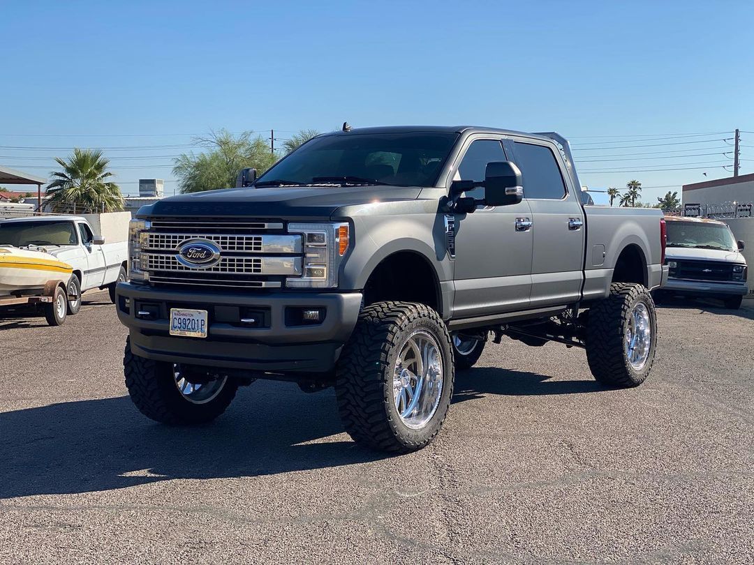 A gray ford truck is parked in a parking lot.