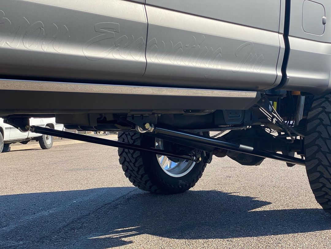 A truck is parked on the side of the road with a trailer attached to it.