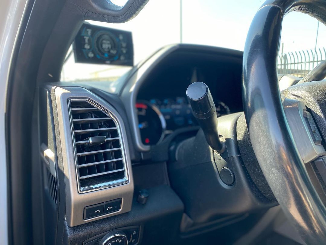 A close up of the steering wheel and dashboard of a car