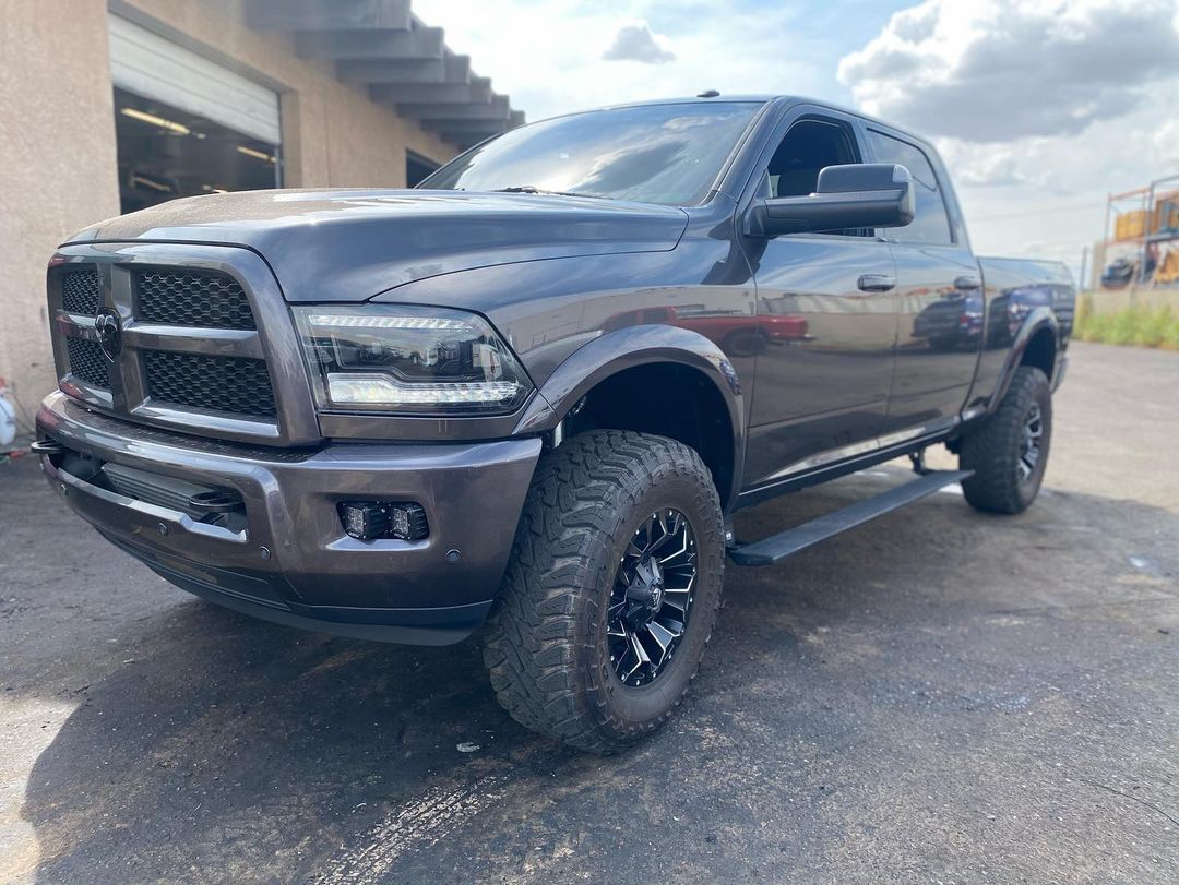A black dodge ram truck is parked in front of a building.