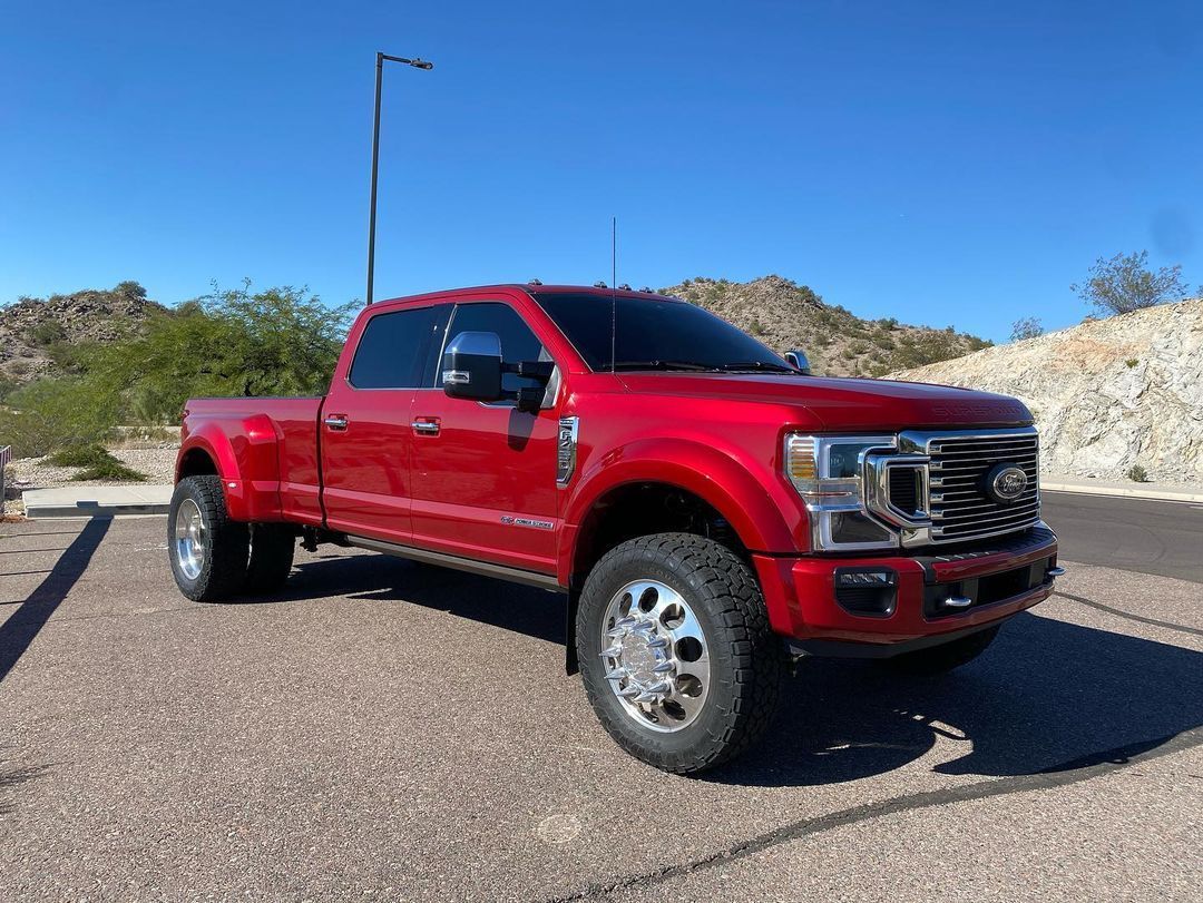 A red pickup truck is parked on the side of the road.