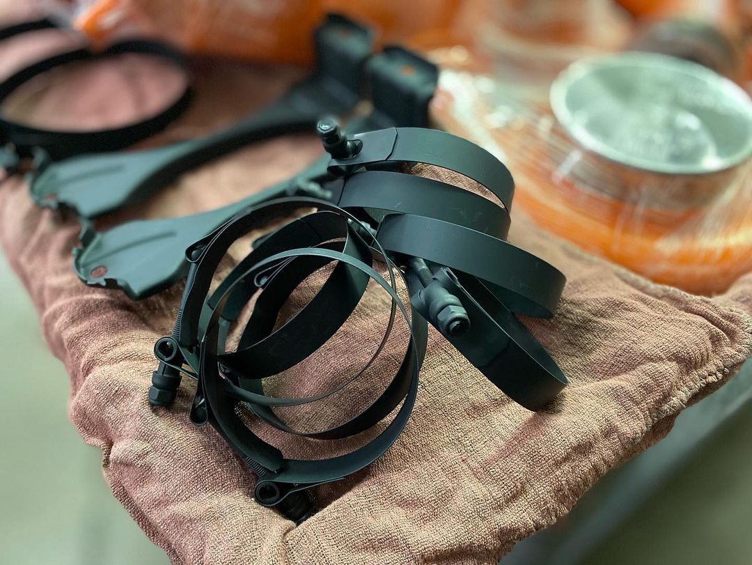 A bunch of black straps are laying on a towel on a table.