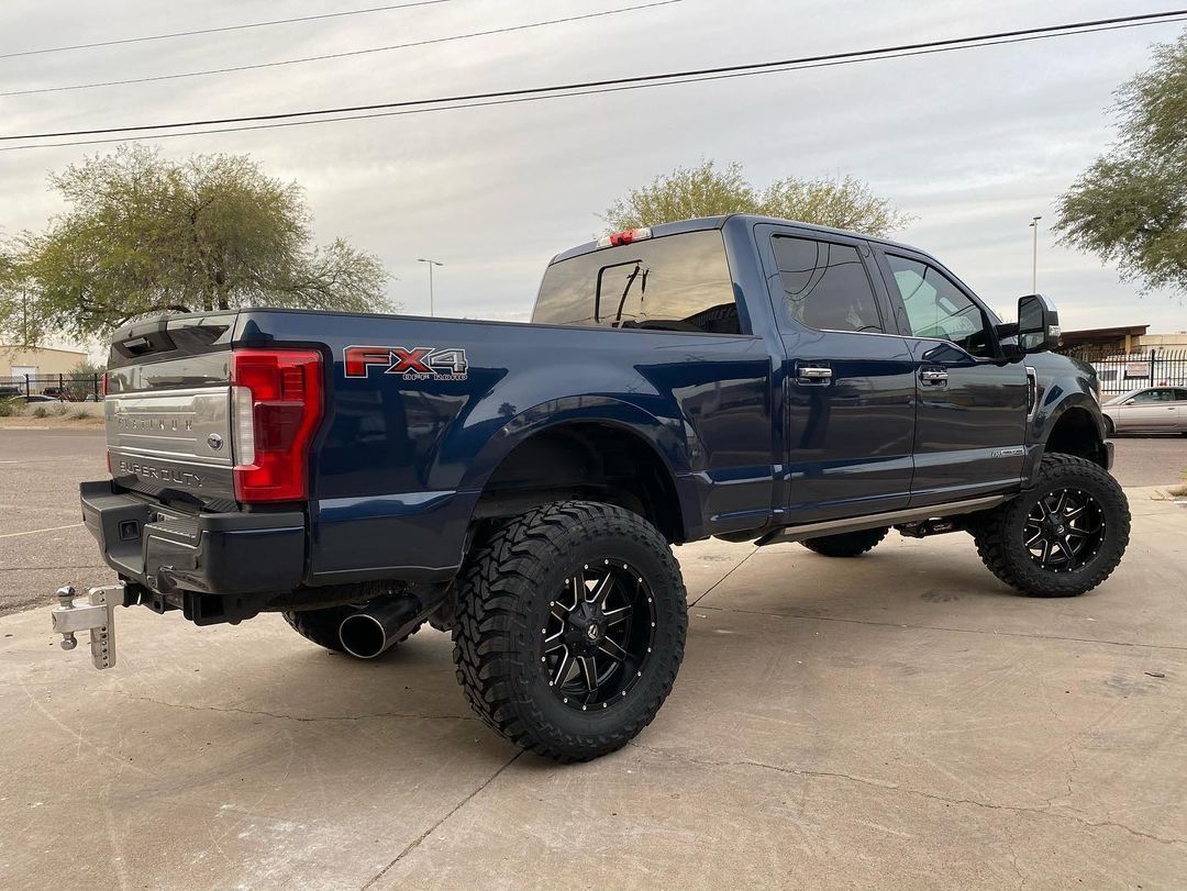 A blue pickup truck is parked on the side of the road.