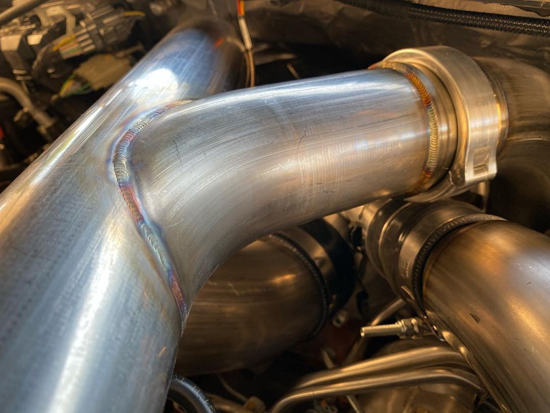 A close up of a metal pipe in a car engine