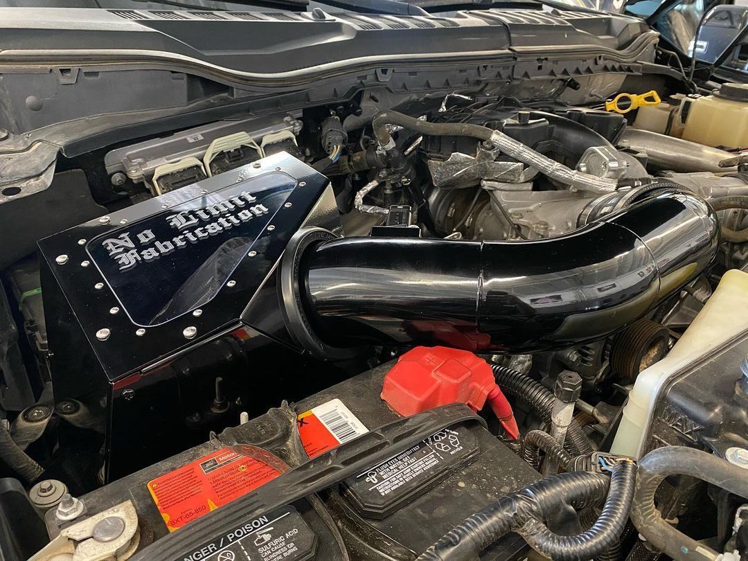 A close up of a car engine with a battery.