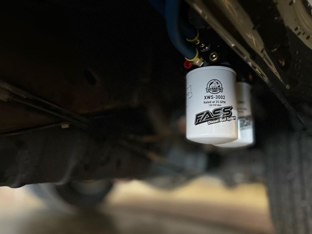A couple of white bottles hanging from the side of a car