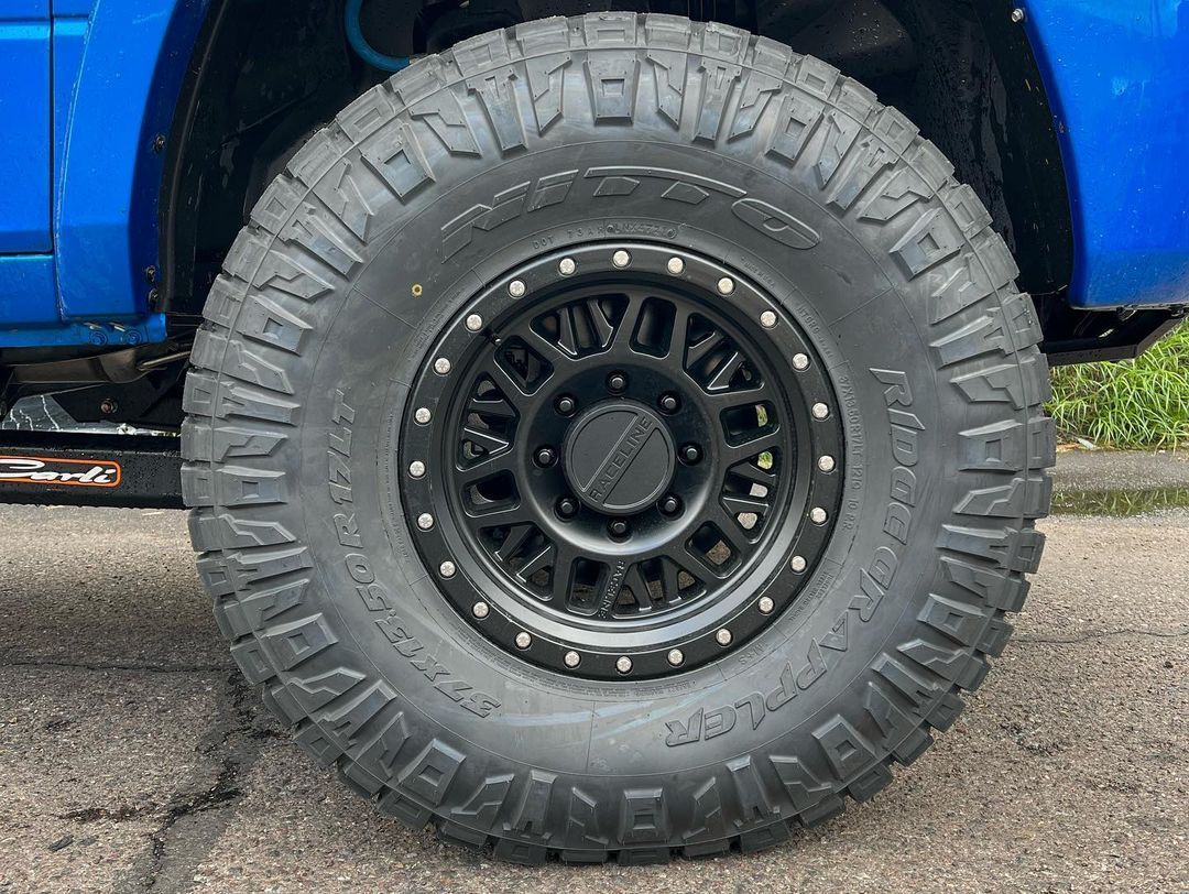 A close up of a tire on a blue truck.