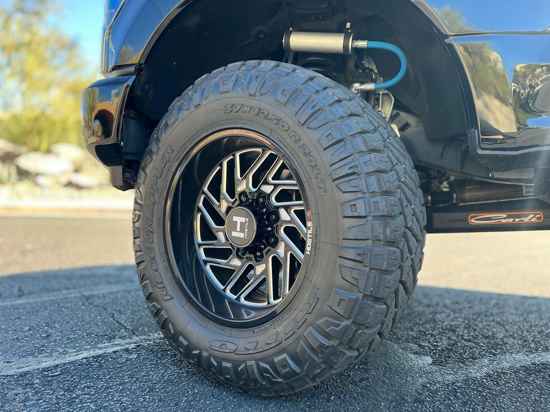 A close up of a truck tire on a road.