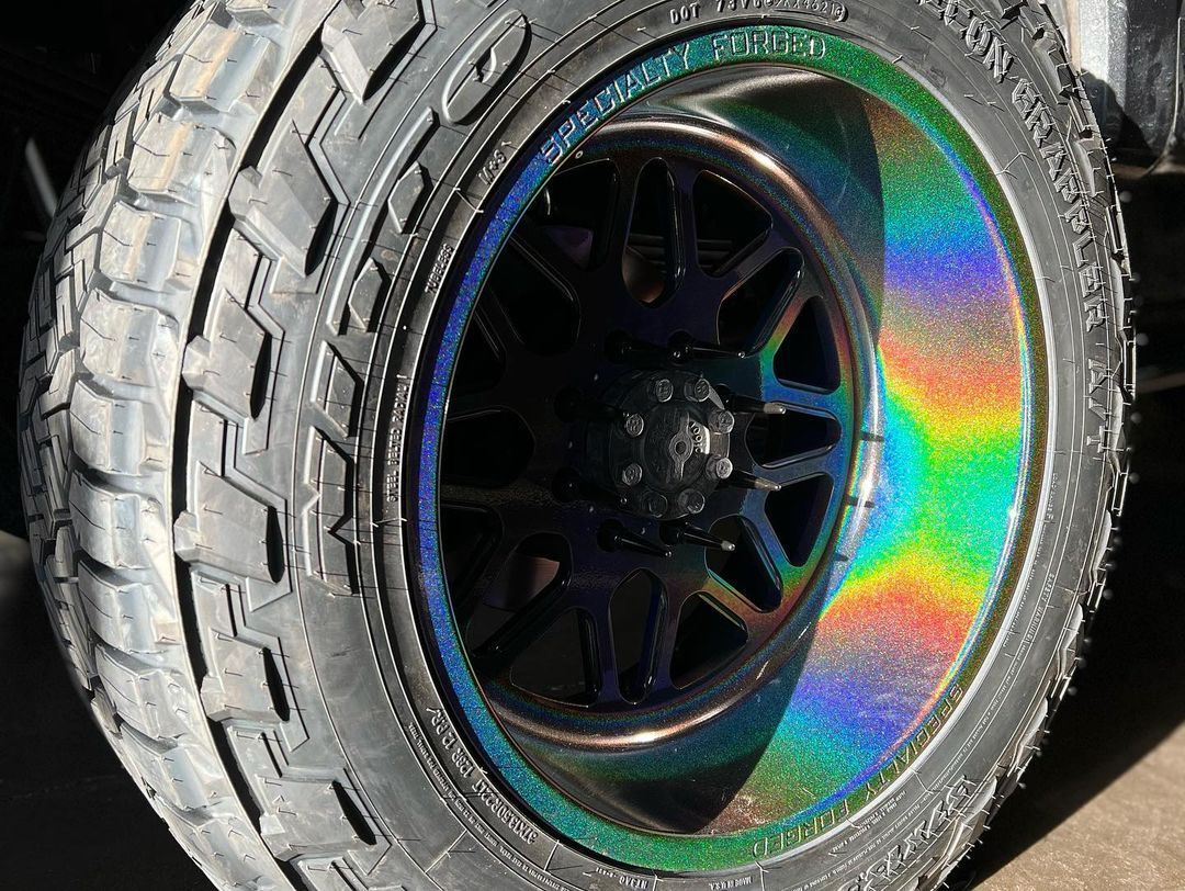 A close up of a tire with a rainbow colored rim.