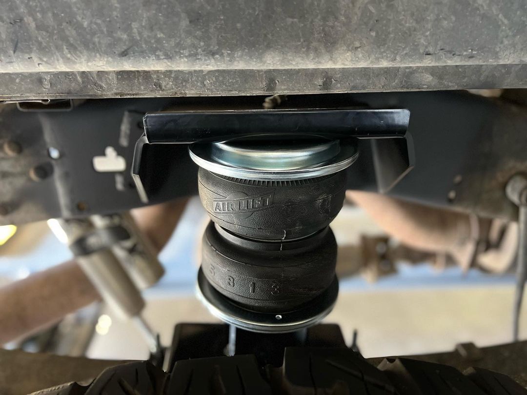 A close up of a shock absorber on a truck.