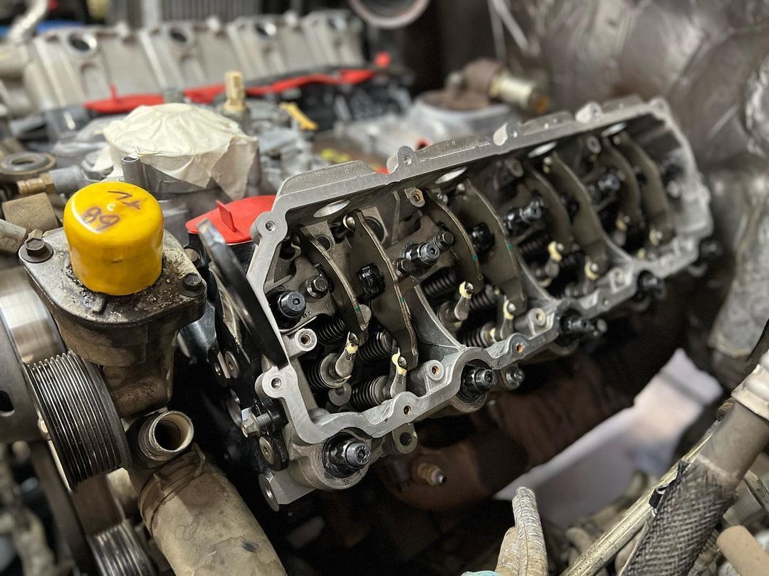 A close up of a car engine with a yellow cap on it.