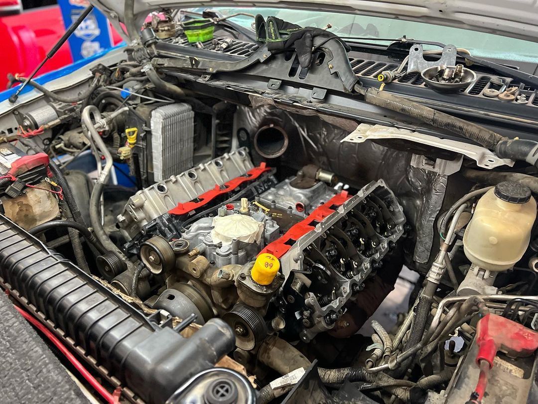 A close up of a car engine with the hood open.