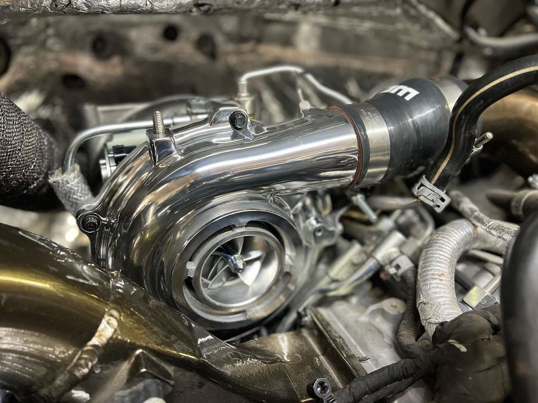 A close up of a turbocharger on a car engine.