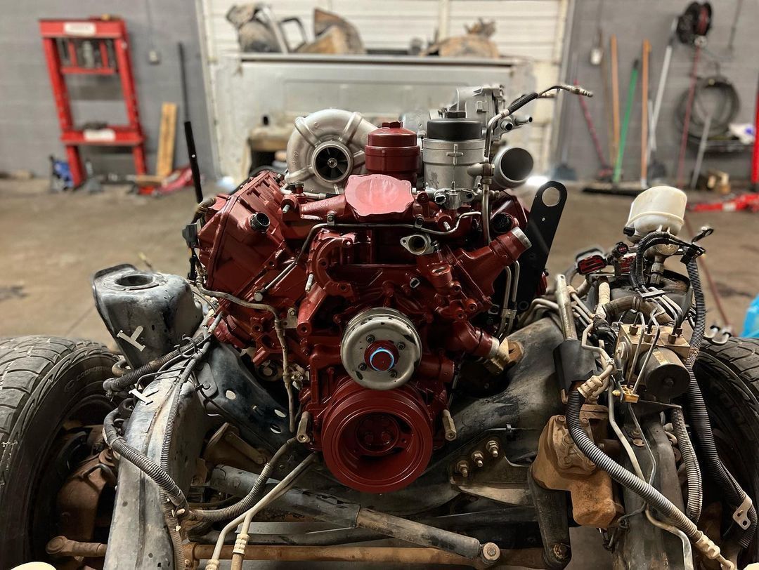 A red and black engine is sitting in a garage.