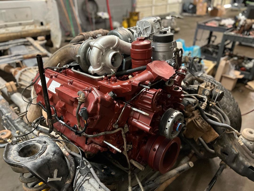 A red engine is sitting on top of a table in a garage.