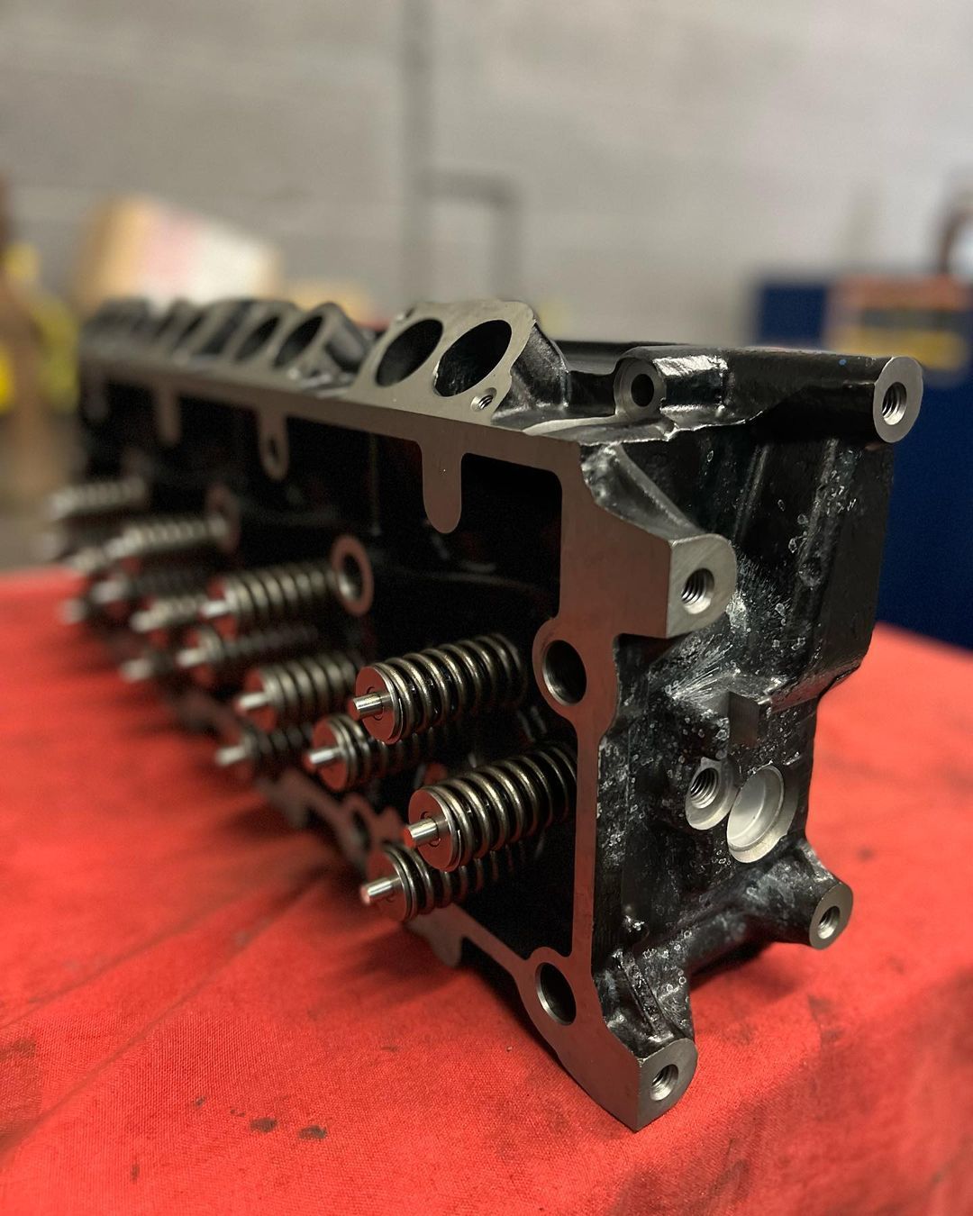A close up of a cylinder head on a red cloth
