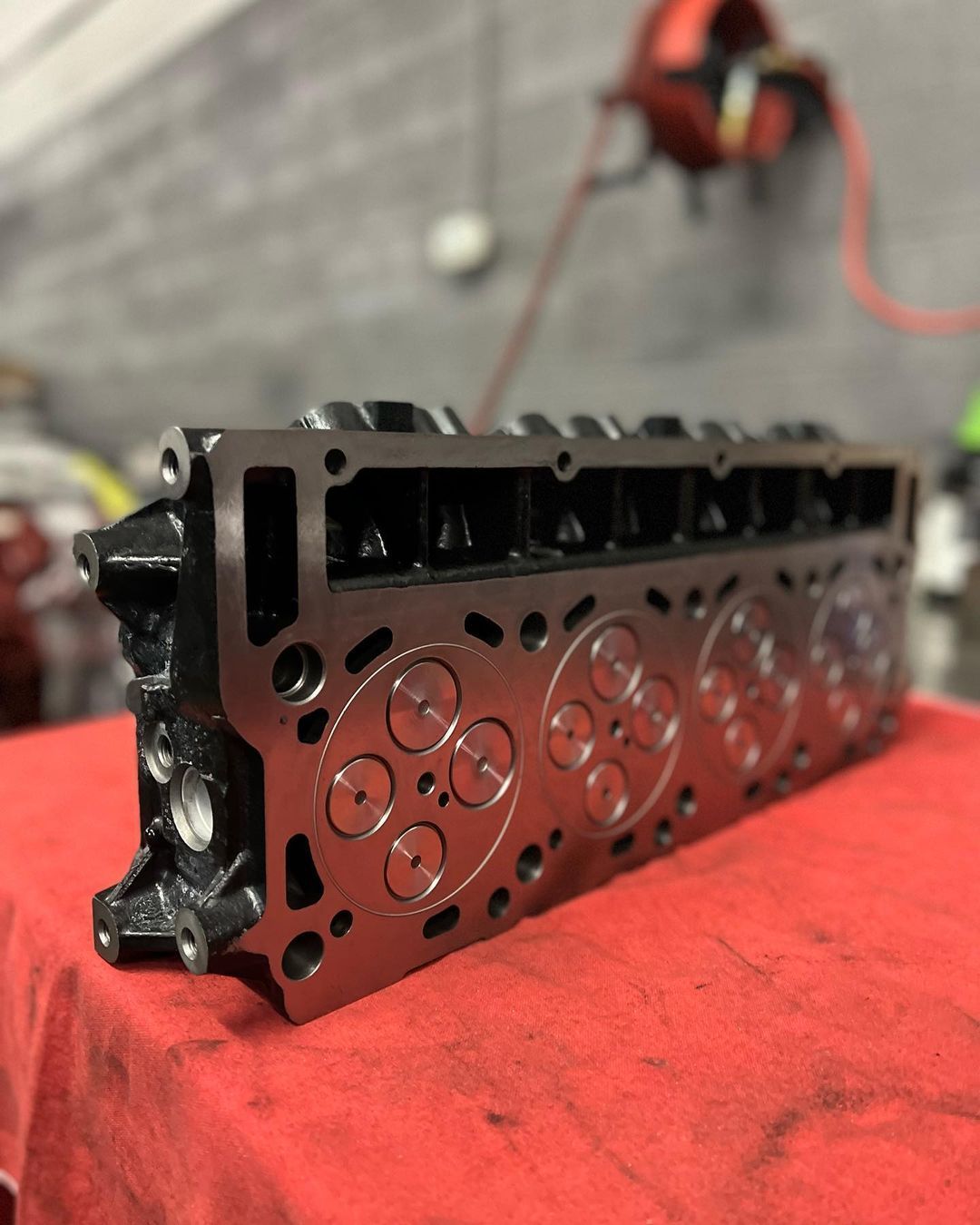 A cylinder head is sitting on a red cloth
