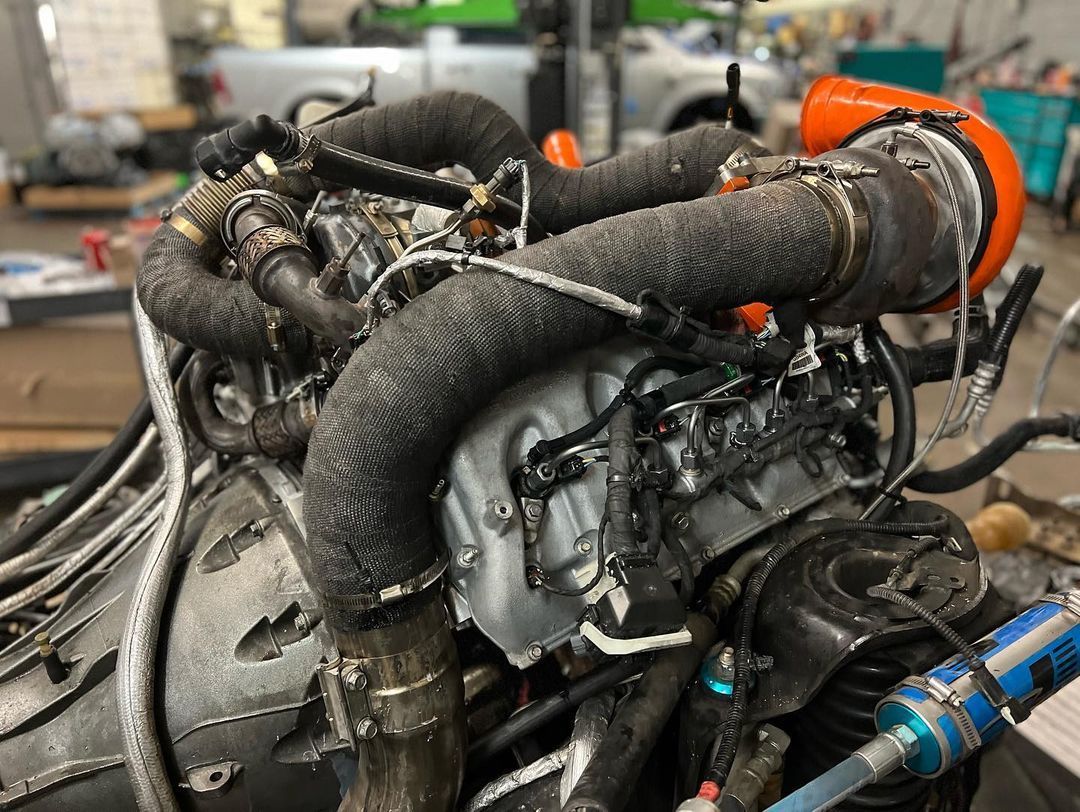 A close up of a very old engine with a lot of hose attached to it.