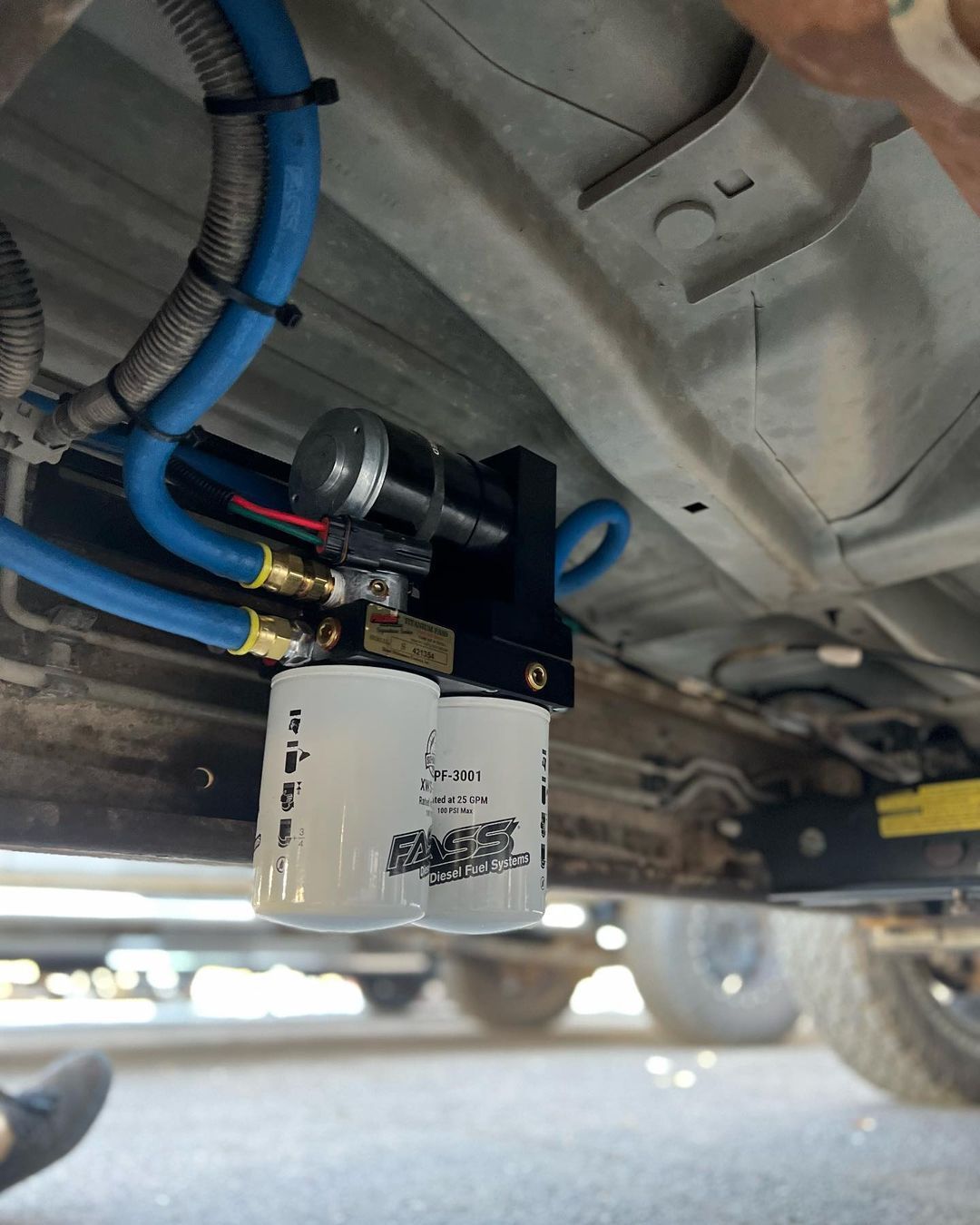 A white oil filter is attached to the underside of a vehicle.