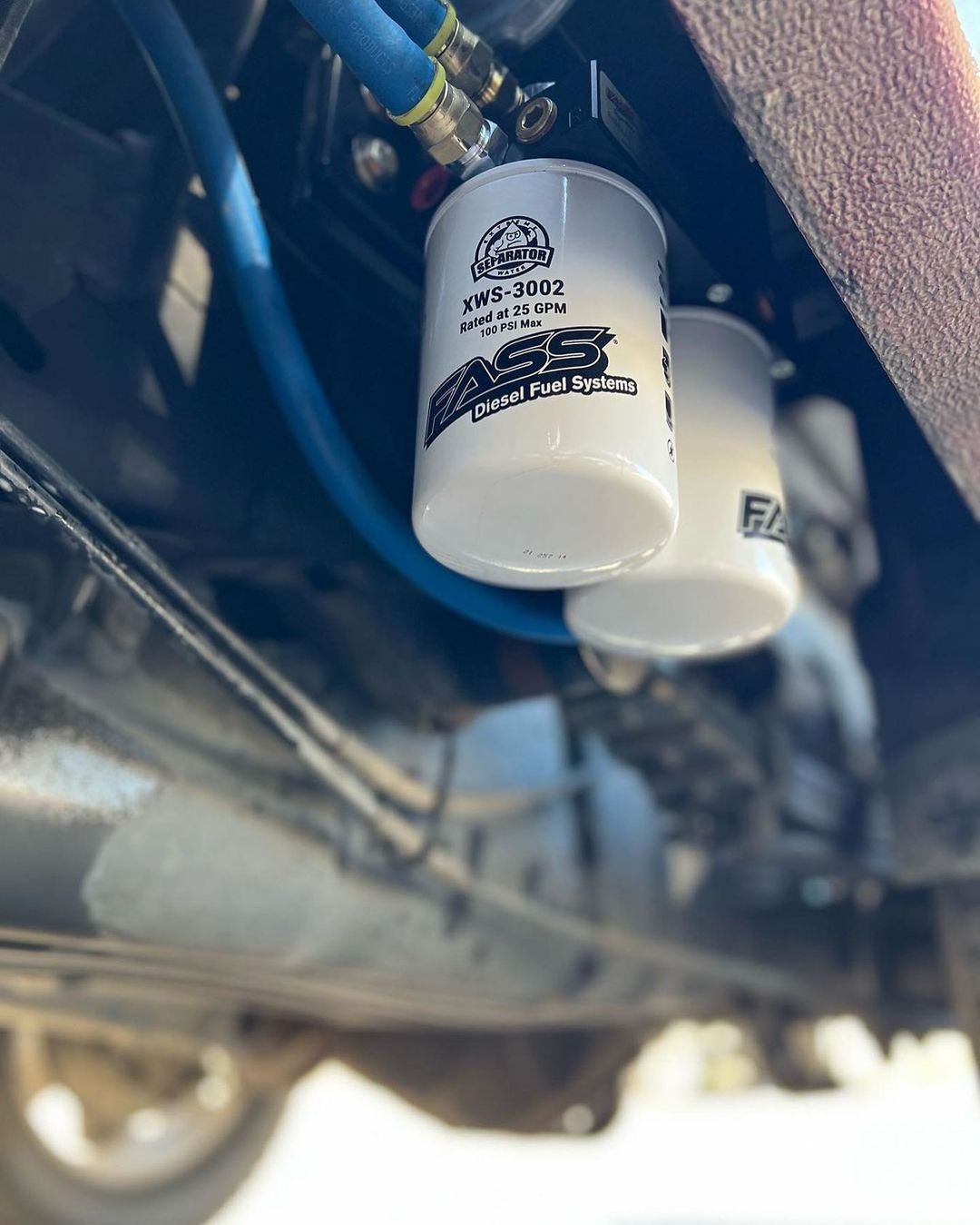 A close up of two oil filters on the underside of a car