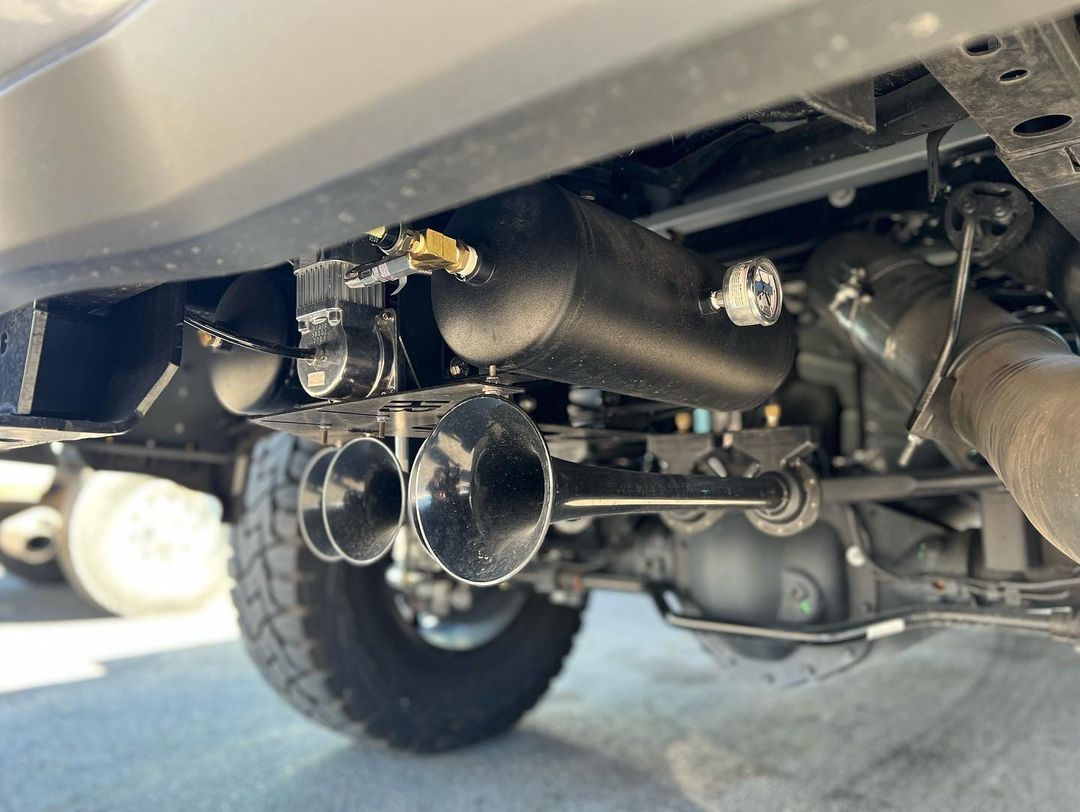 A close up of the underside of a truck with air horns.