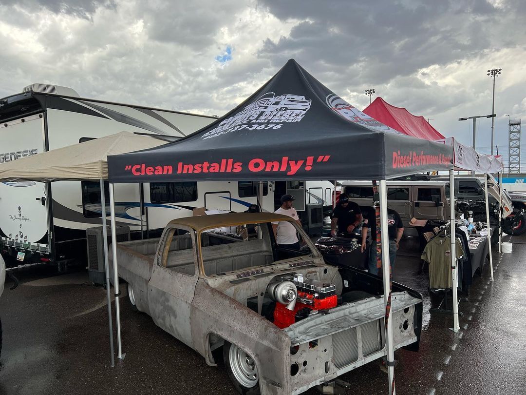 A truck is parked under a tent that says `` clean installs only ''.