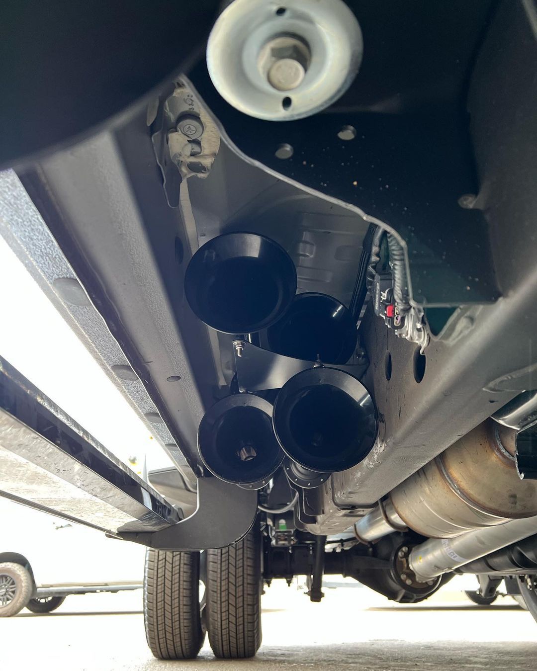 A close up of the underside of a car with a lot of exhaust pipes