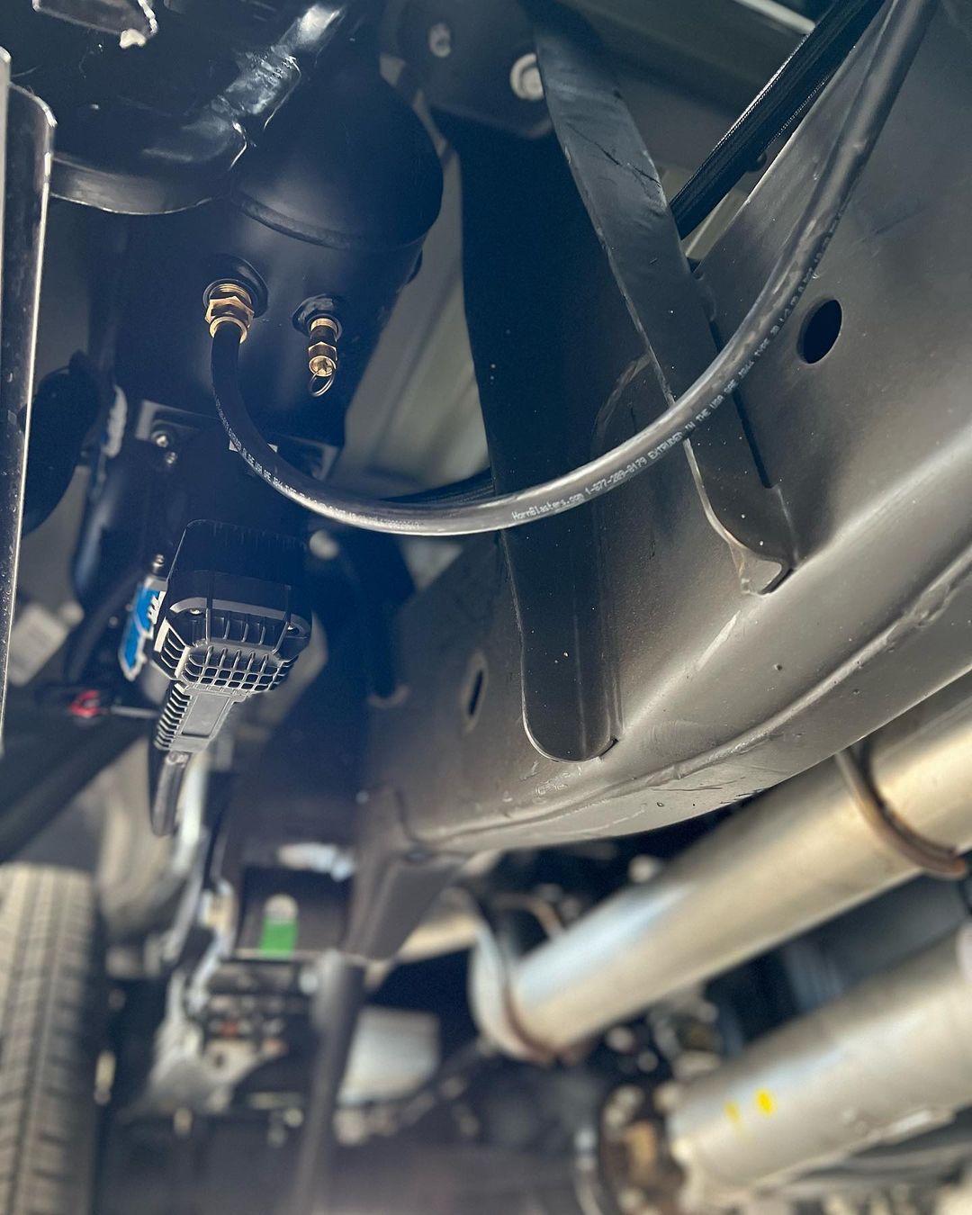 A close up of the underside of a car with a lot of wires coming out of it.