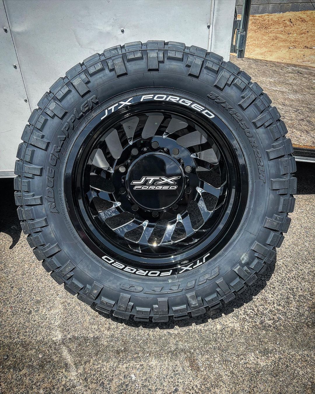 A close up of a tire and wheel on a trailer.