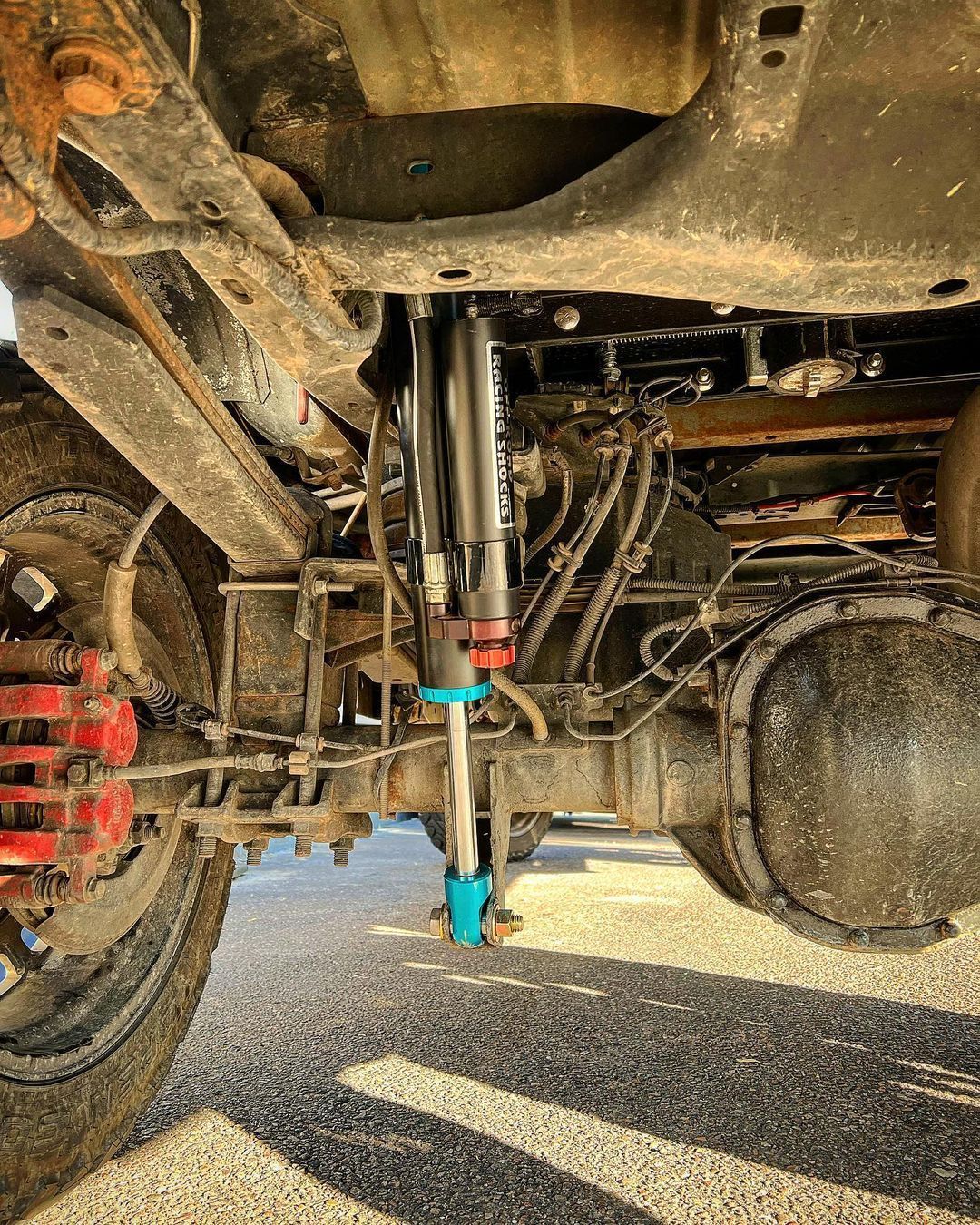 A close up of the underside of a truck with a shock on it.