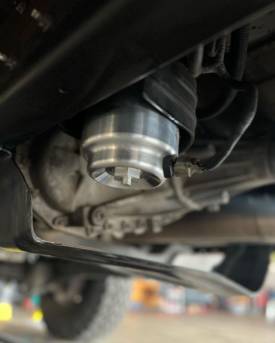 A close up of a metal object underneath a car.