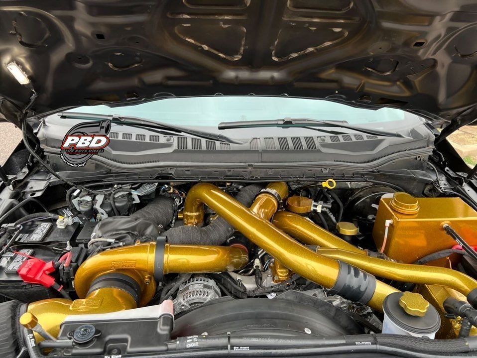 A close up of a car engine with the hood open