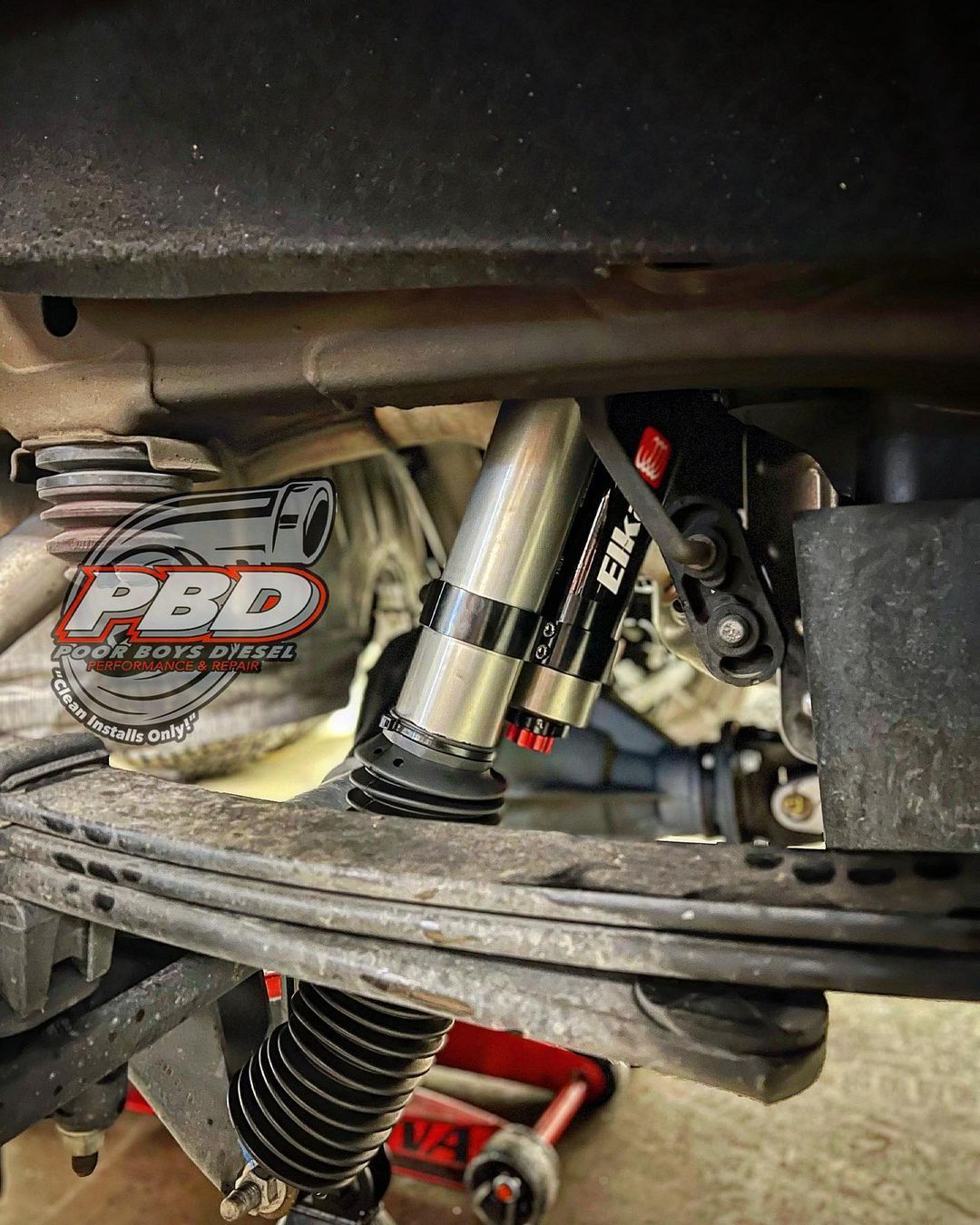 A close up of a shock on the underside of a vehicle.