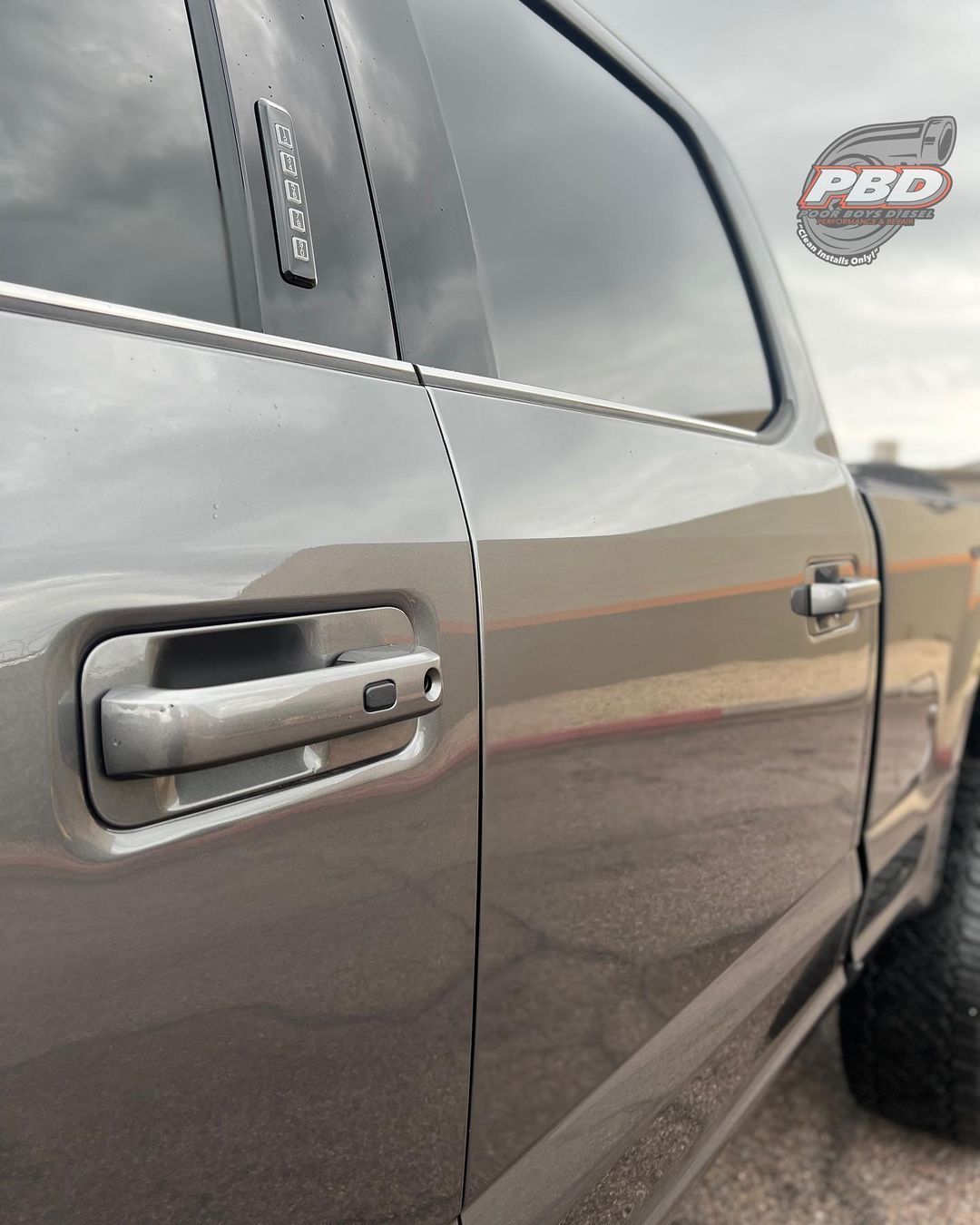 A gray truck with a pbc sticker on the side of it