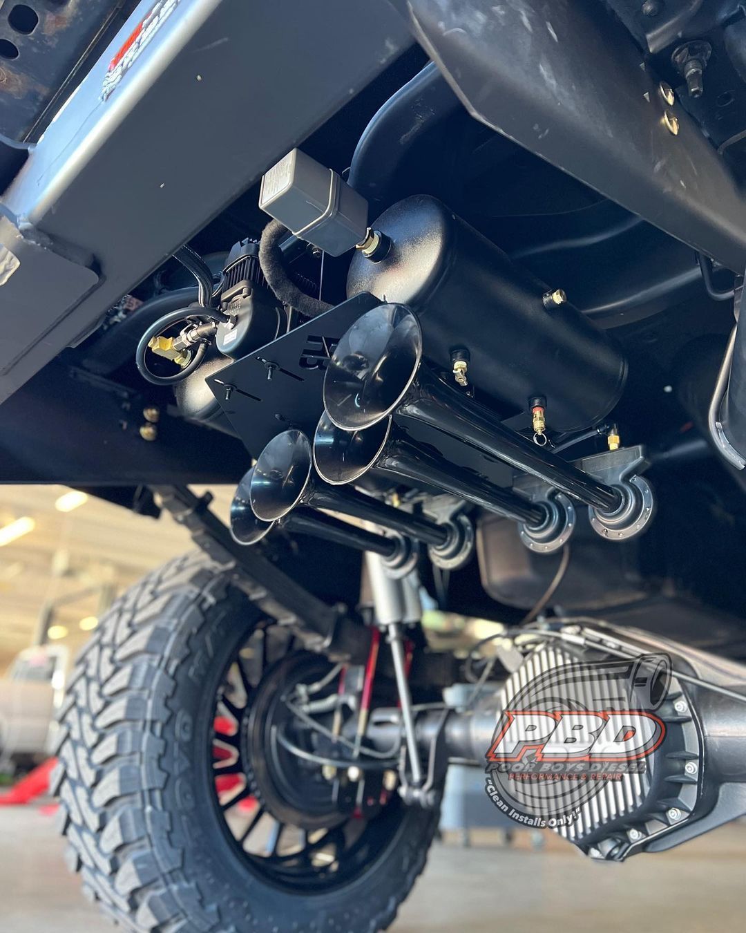 A truck with a lot of horns on it is parked in a garage.