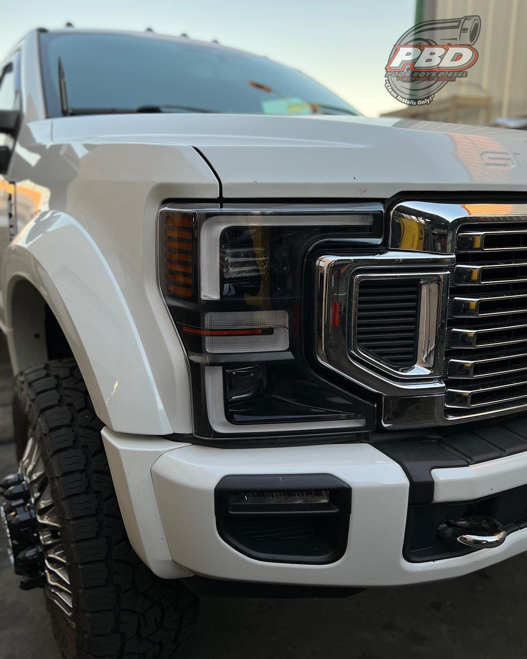 A white truck is parked in front of a building.
