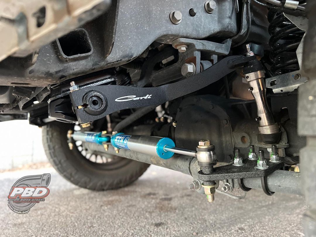 A close up of the underside of a truck 's suspension system.