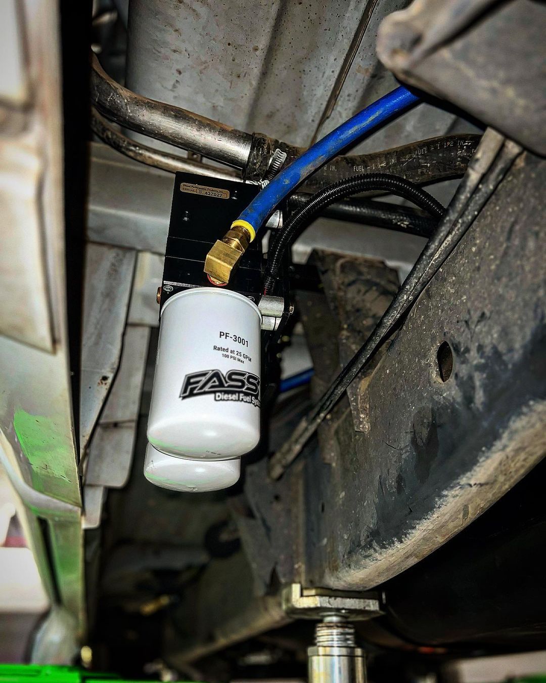 A fuel filter is attached to the underside of a vehicle.