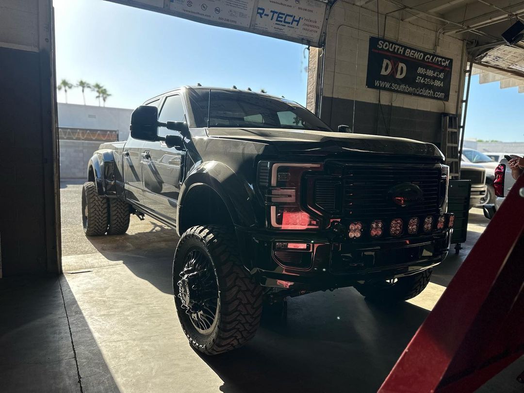 A black truck is parked in a garage.