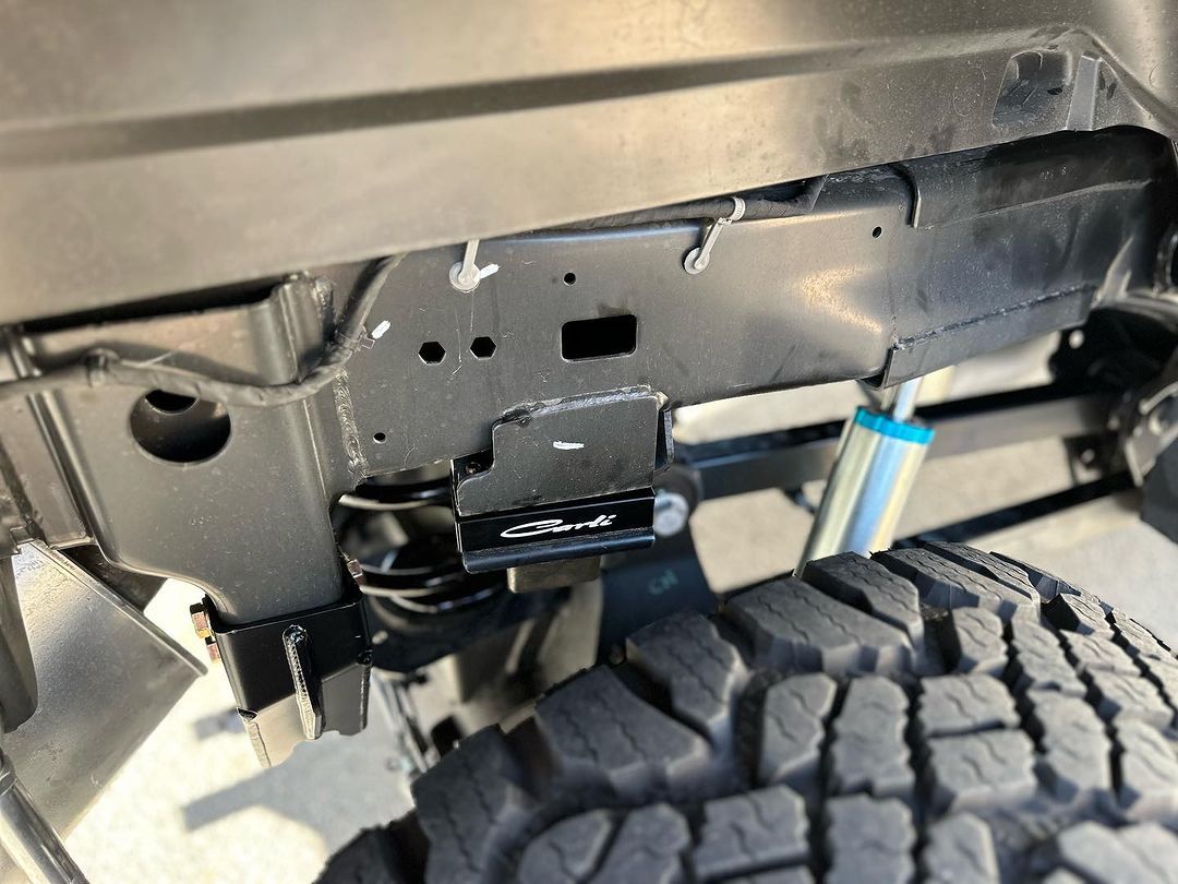 A close up of the underside of a truck with a tire.