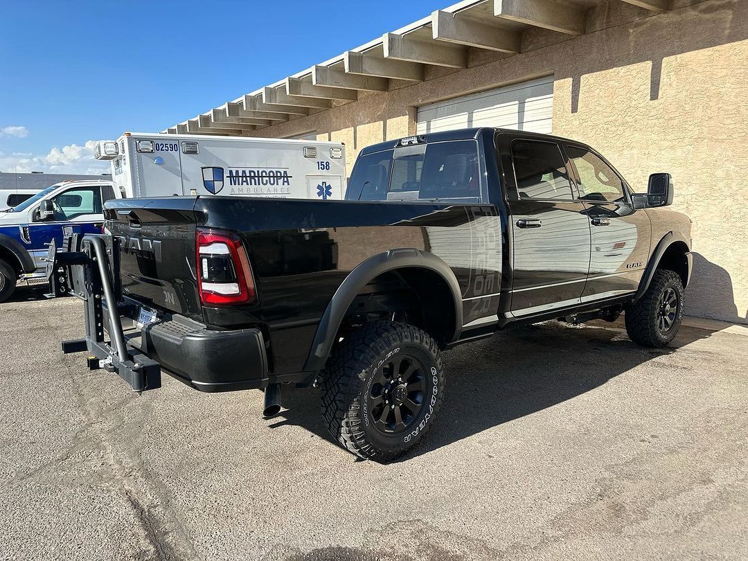 A black truck is parked in front of a building.