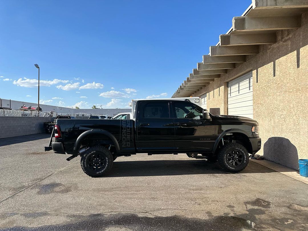 A black truck is parked in front of a building.