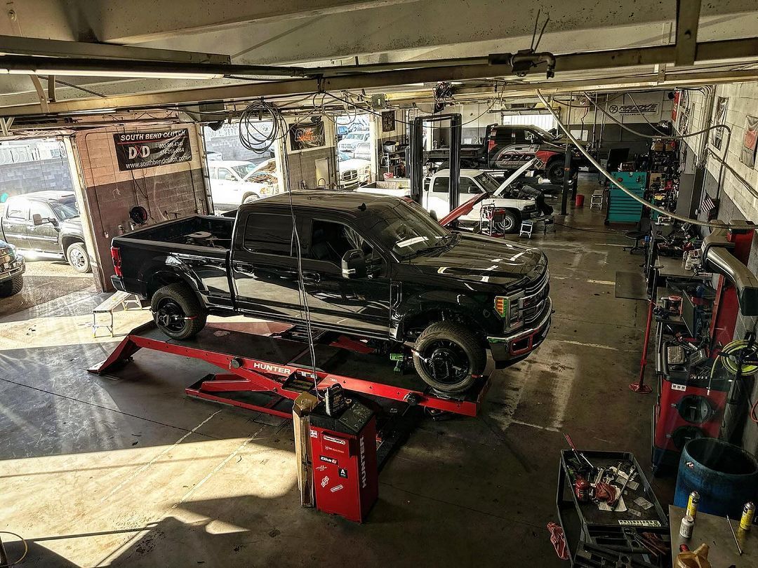 A truck is sitting on a lift in a garage.