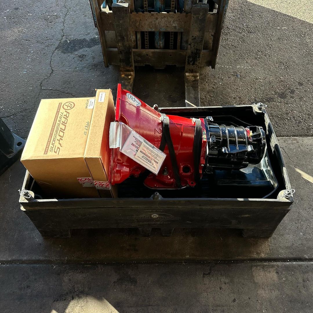 A forklift is carrying a box that says ' ford ' on it