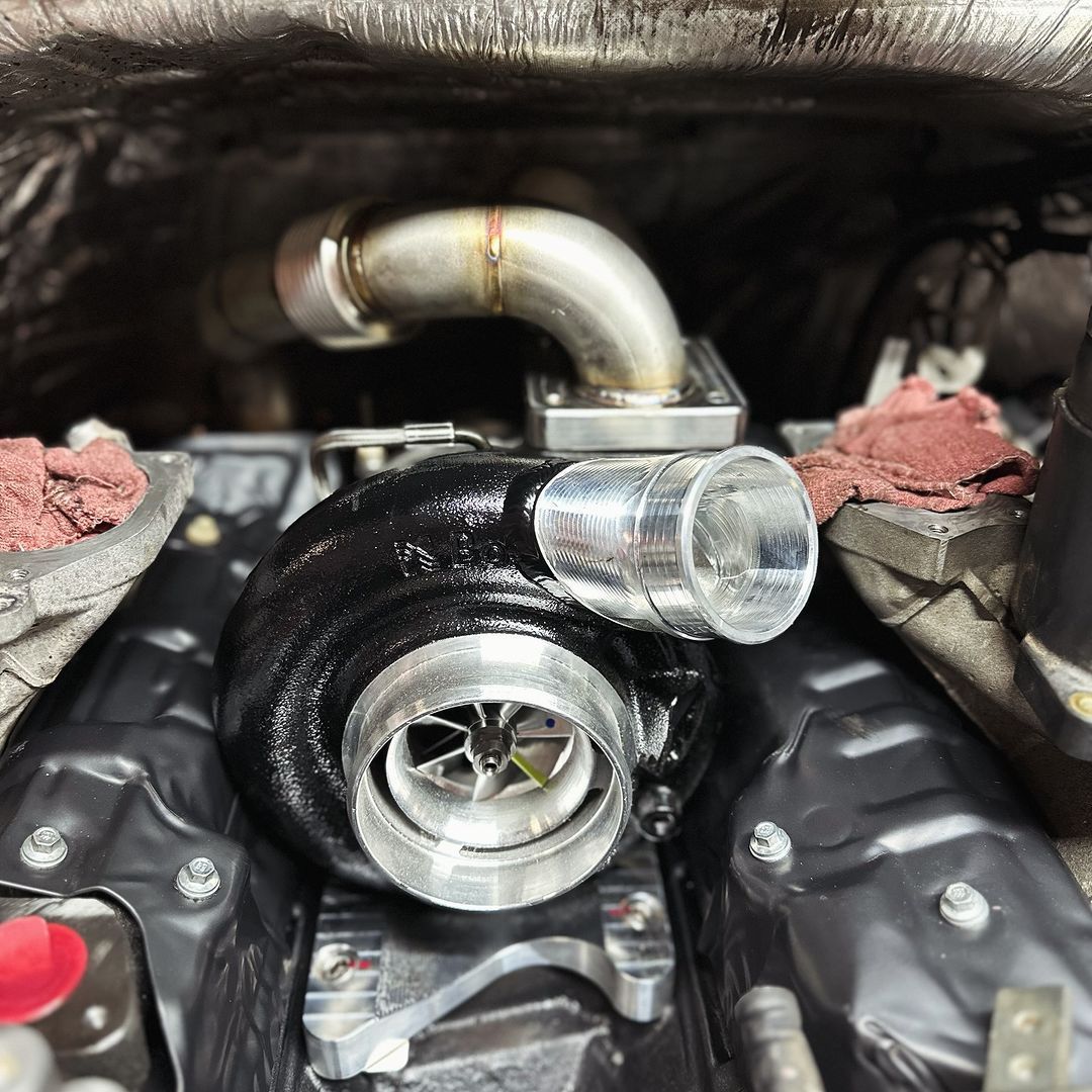 A turbocharger is sitting inside of a car engine.