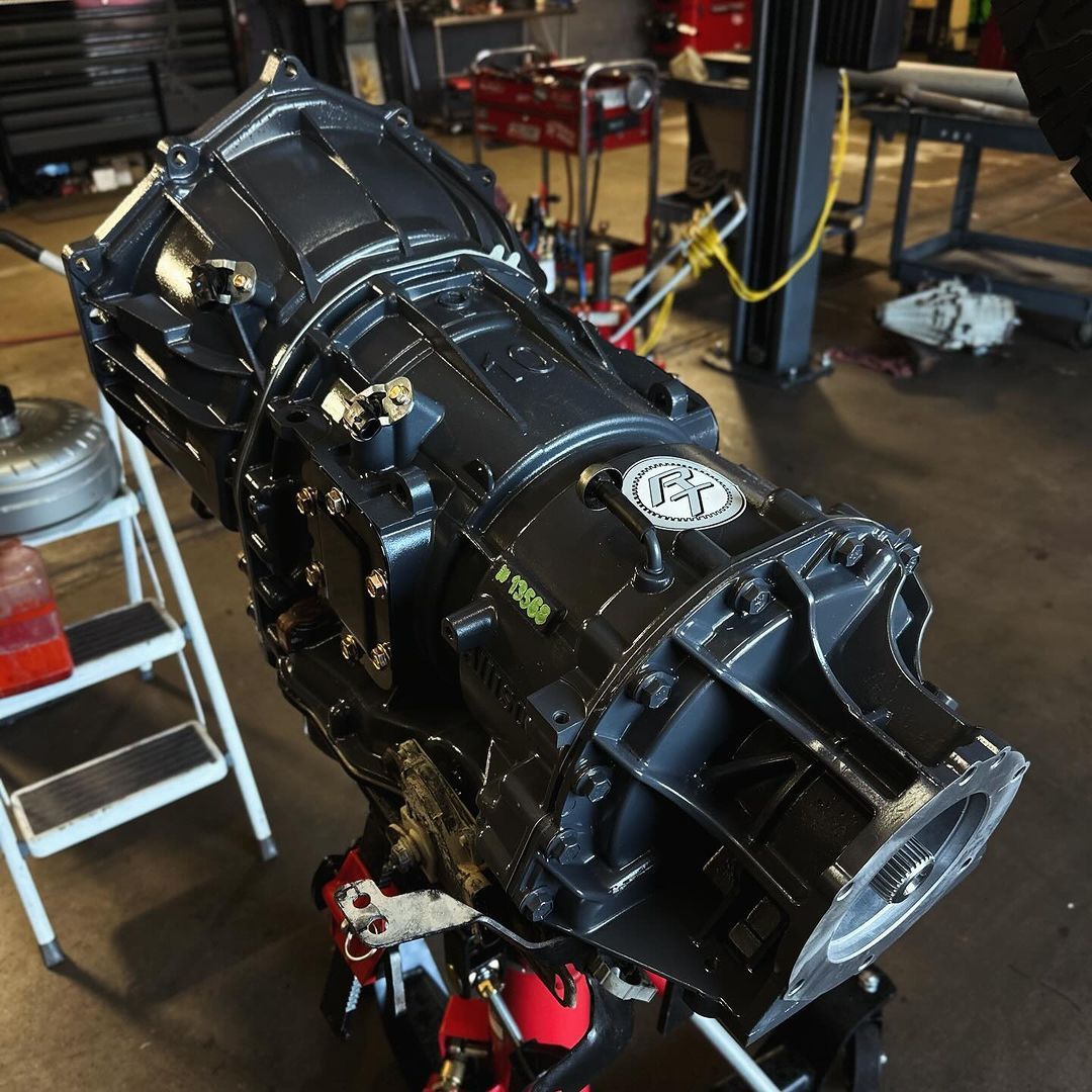 A black gearbox is sitting on a ladder in a garage