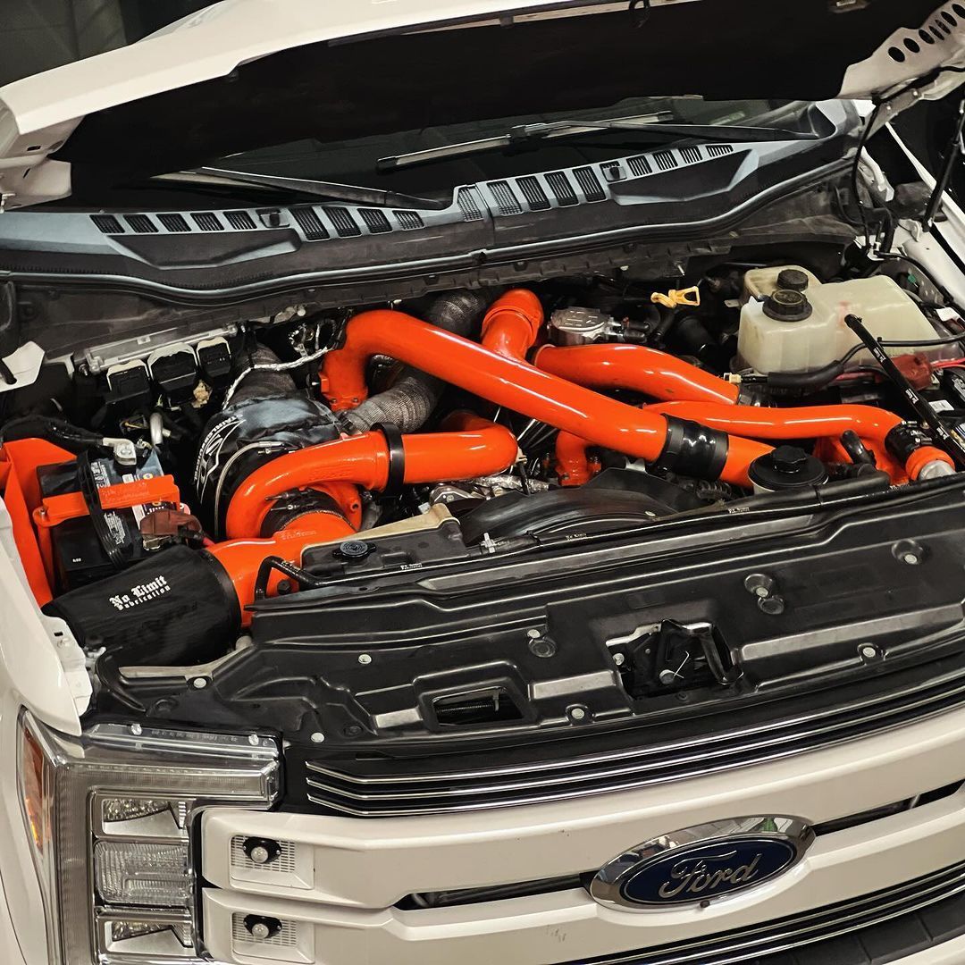 The engine of a white ford truck with the hood open